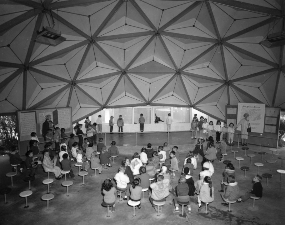 In 1959, some new exhibits and features were added to the Children's Zoo, including the Clark Children's Theater. Its design was a geodesic dome, more than 50 feet in diameter at the base and 18 feet hight, placed over an area of child-height stools and a curved, raised stage. There were backstage areas for both humans and animals and places for information displays out front. It was a flexible space designed for a variety of educational presentations and opportunities for children to learn about animals in greater depth. It was made possible by Mrs. Henry B. Clark, who donated her Point Loma estate to the Zoo.