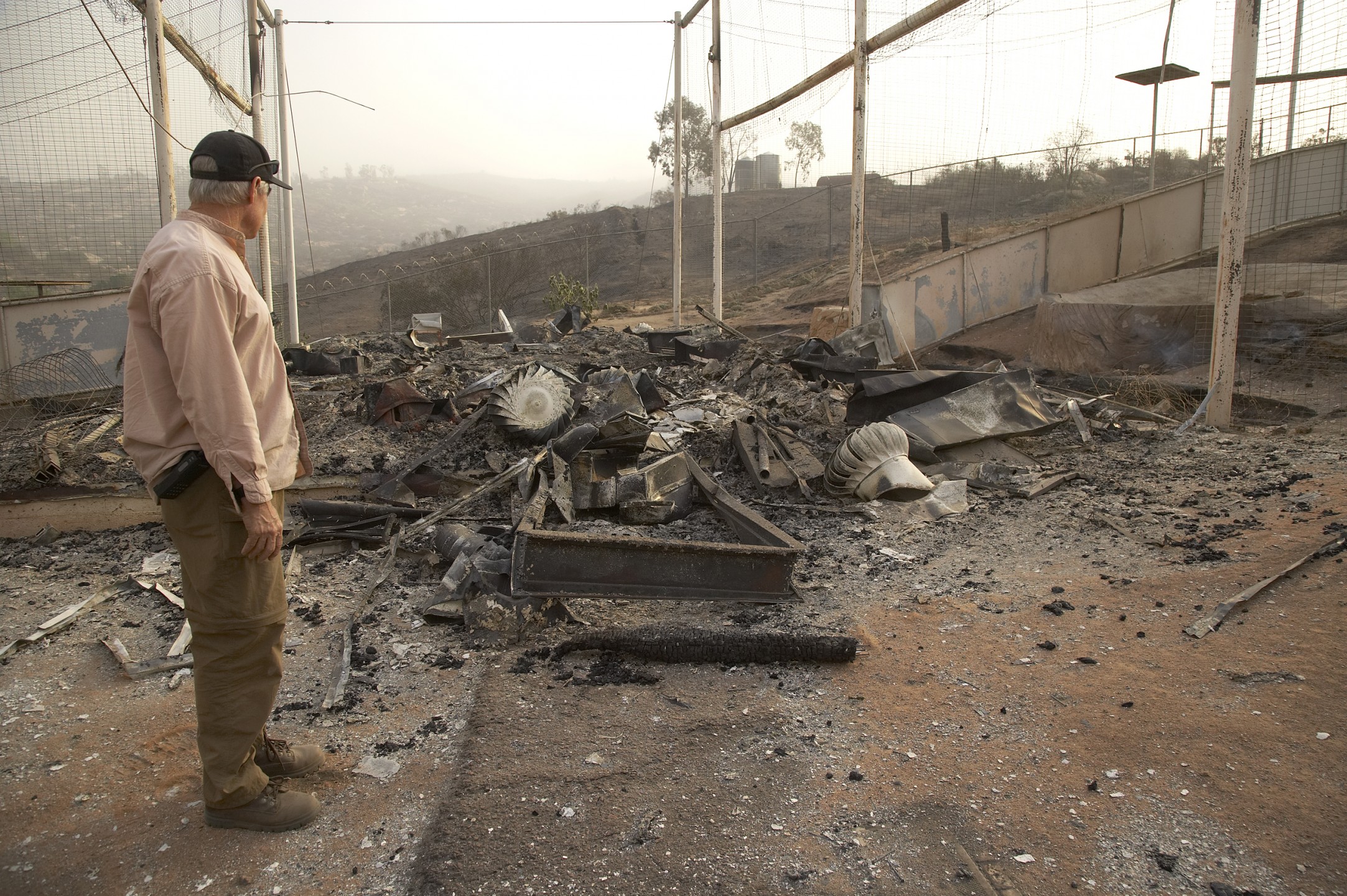 As San Diegans will recall, 2007 was another bad year for wildfires in San Diego—and once again, the Wild Animal Park got burnt around the edges but escaped major injuries and loss of life. It didn't come out unscathed, though. Here, Park bird curator Michael Mace surveys some of the damage to the Condorminium facility. Everyone's main concern was that the condors were alright, but the damage did amount to thousands of dollars.